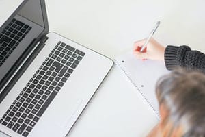 A woman writing a blog post working from home